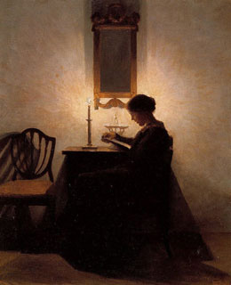 elegant woman seated, reading by candlelight