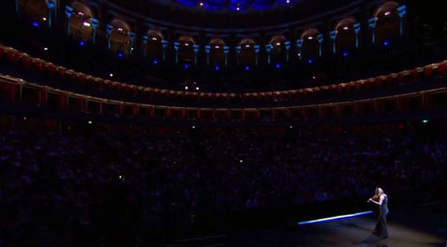 Darkened auditorium of Royal Albert Hall, circular, with solo violinist lower right