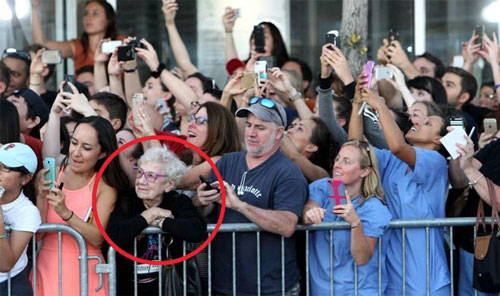 group of excited and observant people with cameras and phones