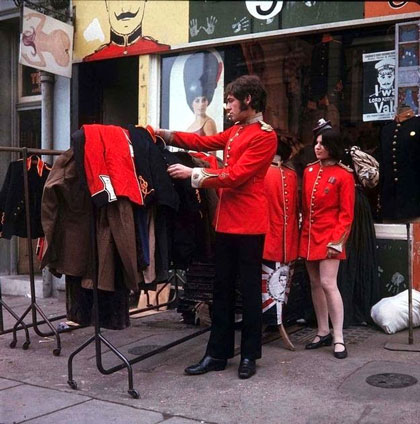 young people outside clothes shop in 60s London, red tunics
