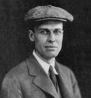 black and white photo of 30's man in flat cap and glasses, the artist Edward Hopper
