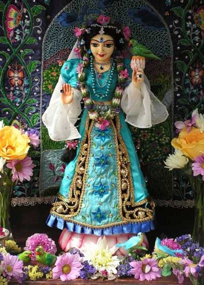 Indian religious icon, lady in blue-green dress with garland