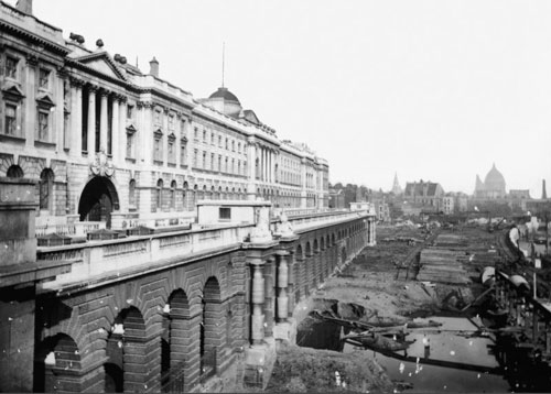 black and white photo shows construction work by river Thames