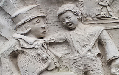 detail from a relief sculpture showing an altercation between two boys