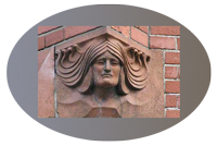 small photo of corner sculpture on brick building, head