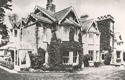 19th-century house and front garden, corner view with gabled rooftops