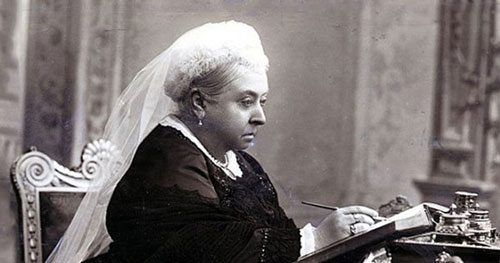Elderly Victorian lady, Queen Victoria, seated at writing desk