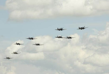 group of small airplanes, spitfires, against sky