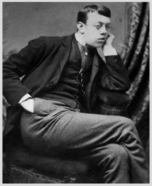 photo of young bespectacled victorian gentleman seated, chin resting on hand, pensive